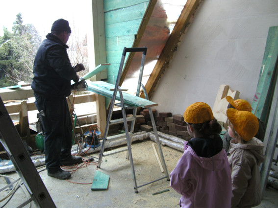 Die Kinder schauen dem Handwerker zu